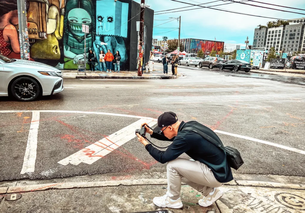 Mann der gerade ein Auto am Straßenrand fotografiert