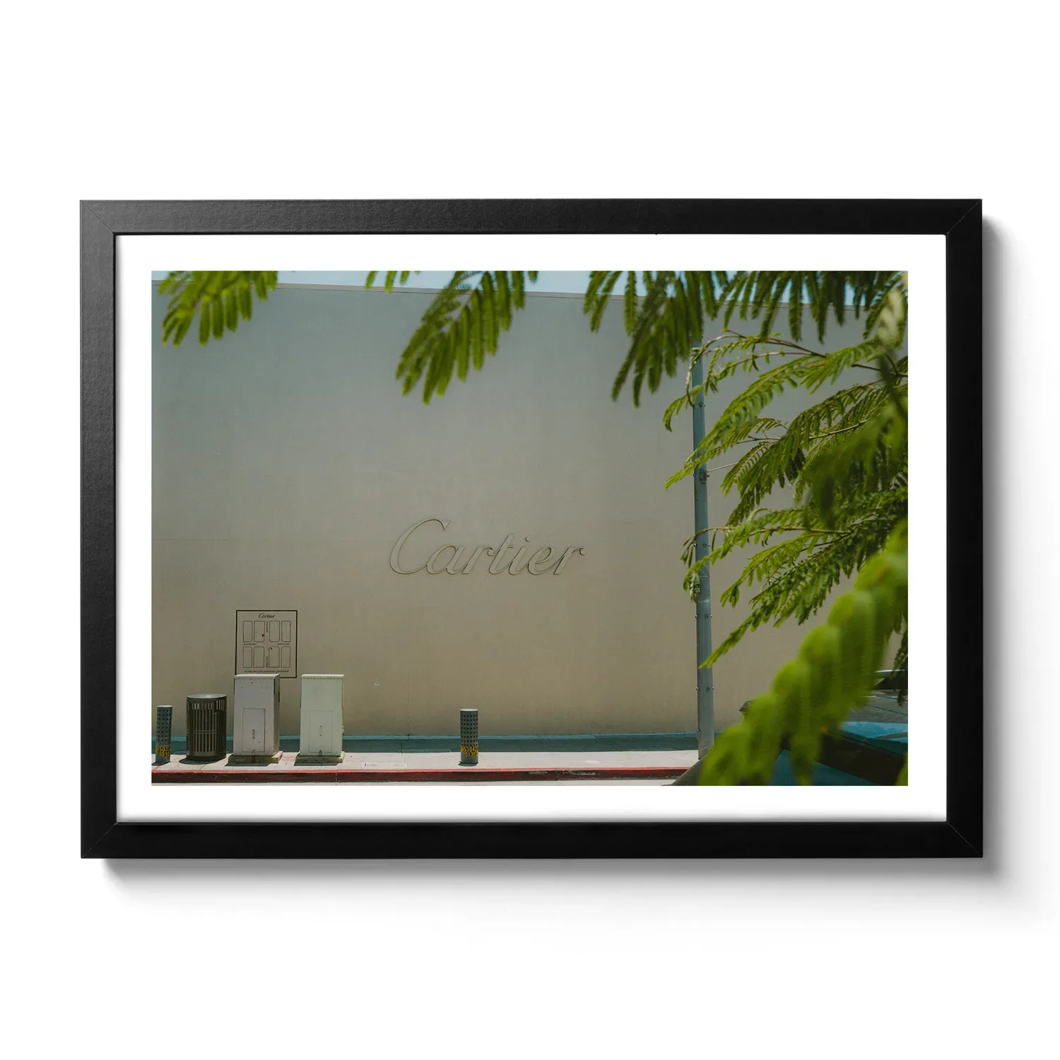 Bildaufnahme von einer beigen Wand mit großem Cartier Schriftzug.