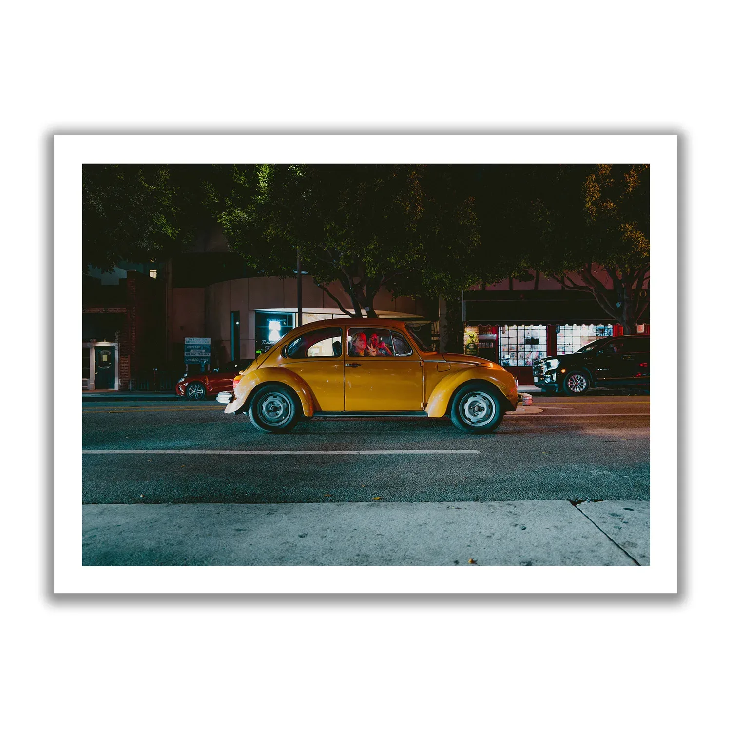 Image of an orange VW Beetle with a woman waving out with the hand gesture "Peace".