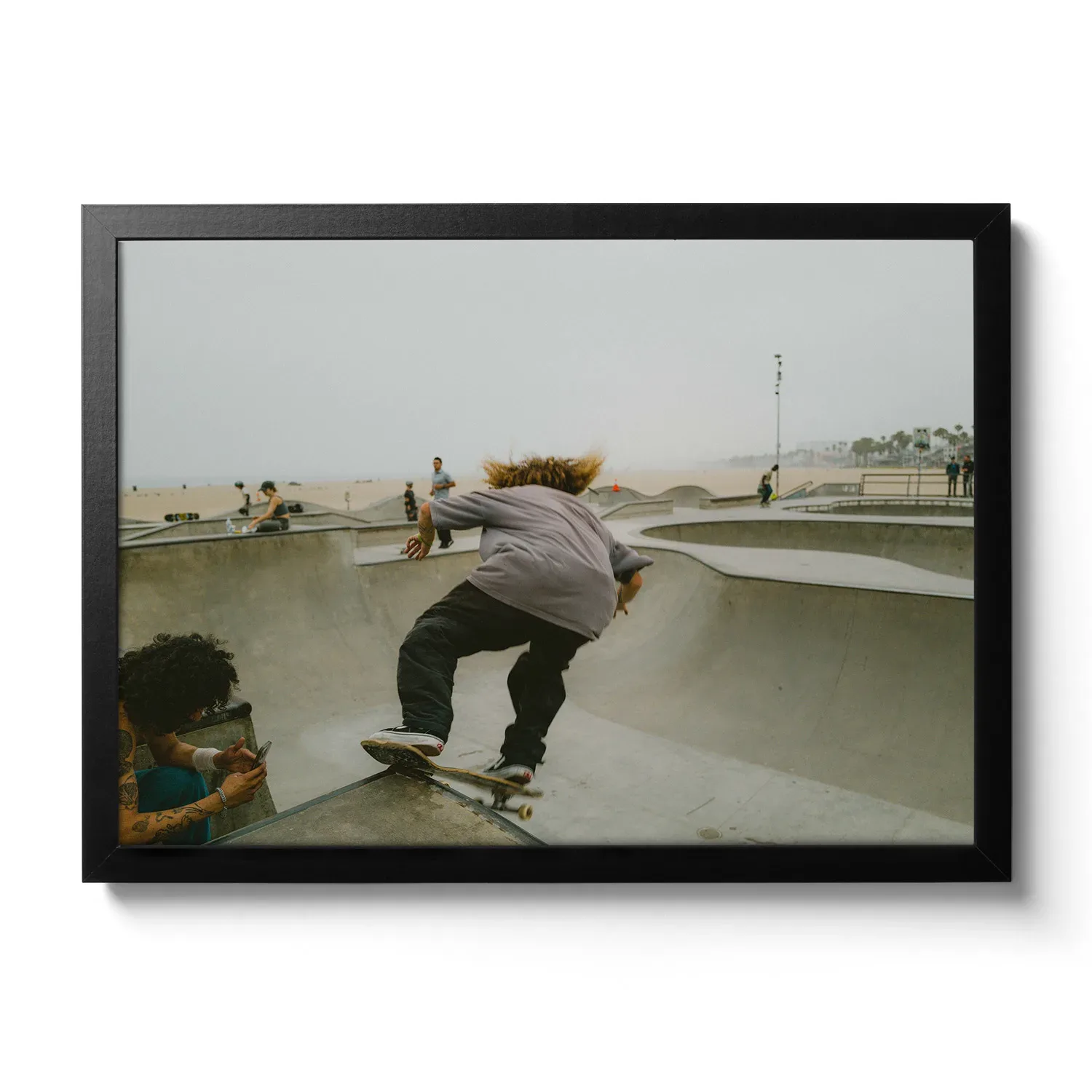 Skater Boys Skate Boarder der gerade in der Half Pipe von Venice Beach cruised.
