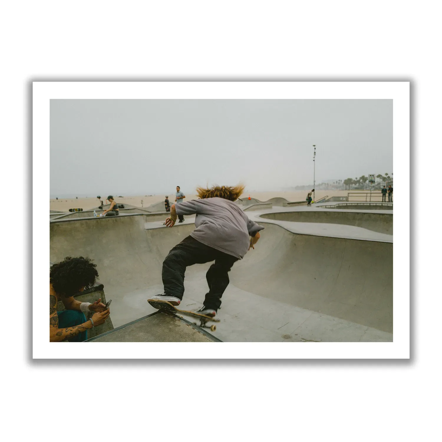 Skater Boys Skate Boarder der gerade in der Half Pipe von Venice Beach cruised.