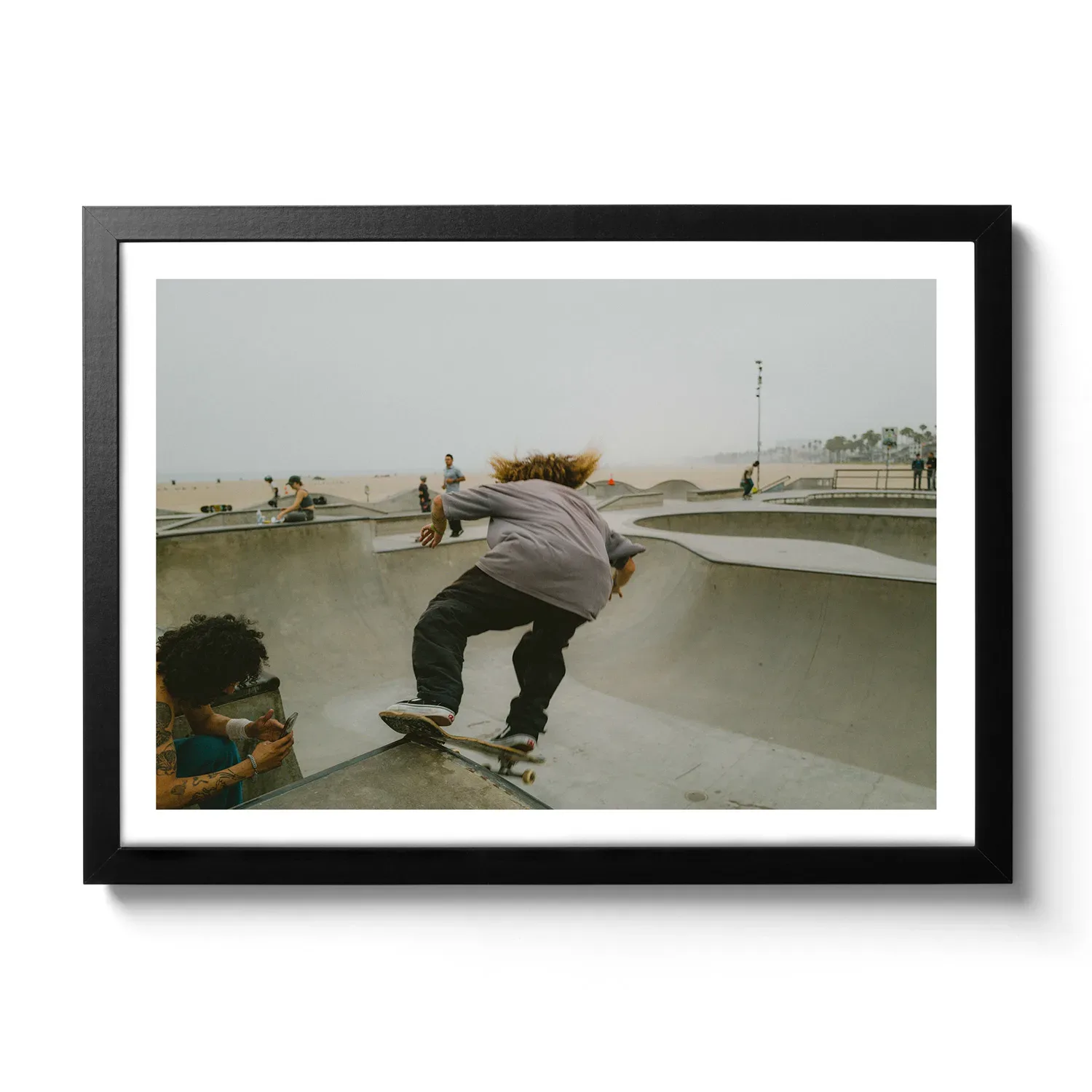 Skater Boys Skate Boarder der gerade in der Half Pipe von Venice Beach cruised.