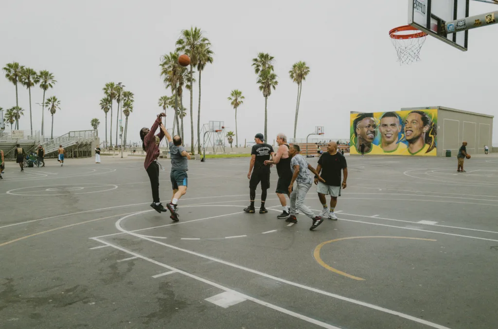 Gruppe Männer spielt Basketball in Venice Beach.