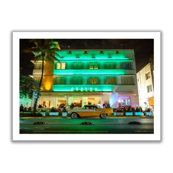 Landscapeaufnahme vom Avalon Hotel Miami am Ocean Drive mit einem gelben Oldtimer davor.