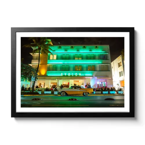 Landscapeaufnahme vom Avalon Hotel Miami am Ocean Drive mit einem gelben Oldtimer davor.