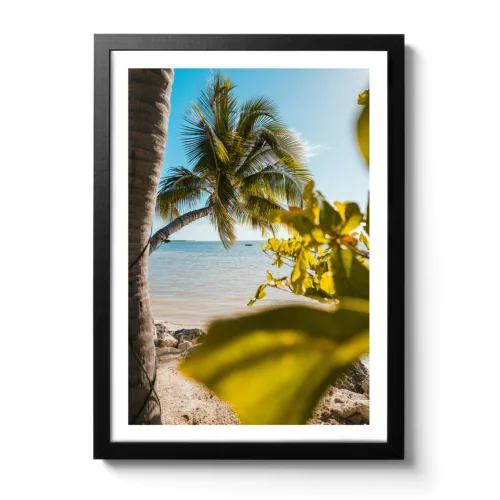 Bildaufnahme eines kleinen Boots, das man draußen am Horizont erkennt. Es wurde durch Palmen fotografiert.