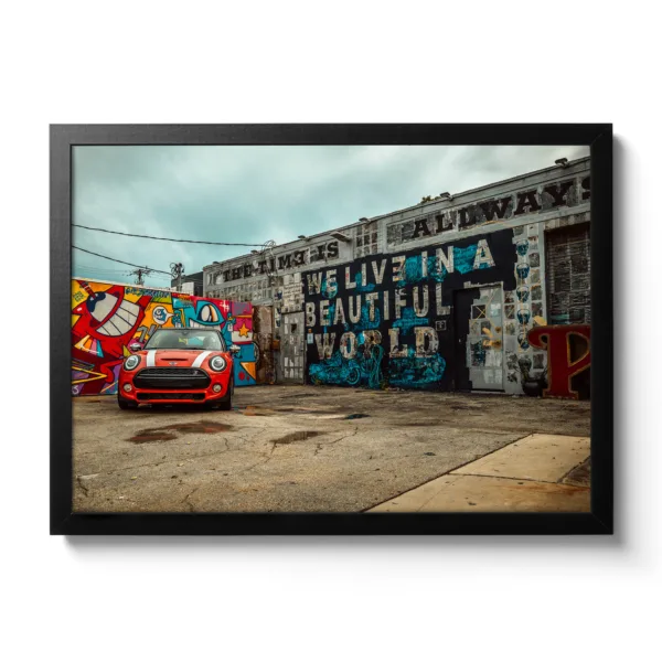 Image of a car repair shop painted with graffiti and a red Mini parked in front of it.