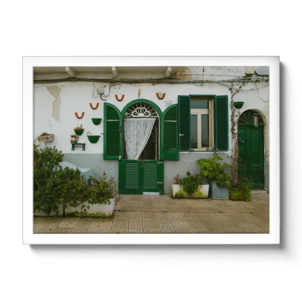 Image of a small Italian house wall with green shutters.