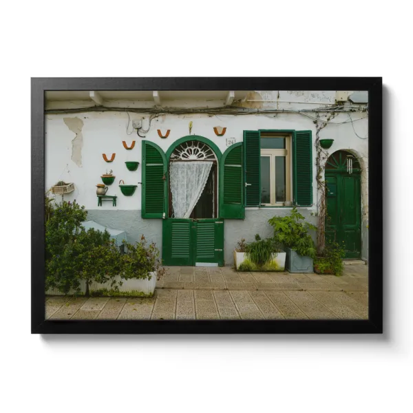 Image of a small Italian house wall with green shutters.
