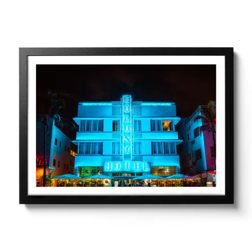 Bildaufnahme bei Nacht vom Colony Hotel Miami. Blaue Neonlichter und Palmen