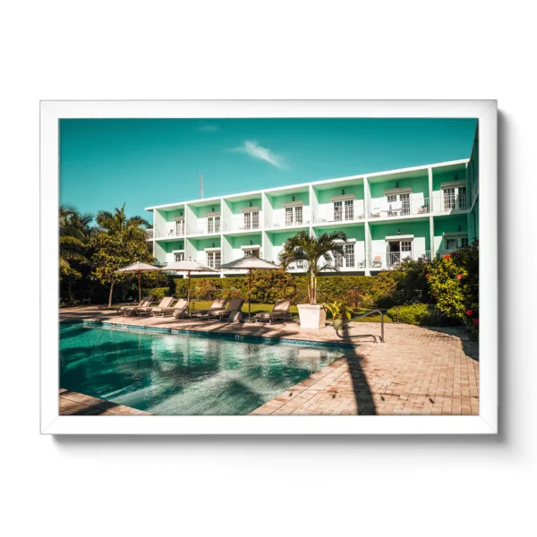 Picture of the pool area of the Grassy Flat Hotel. Blue sky, pool and loungers. Morning view.