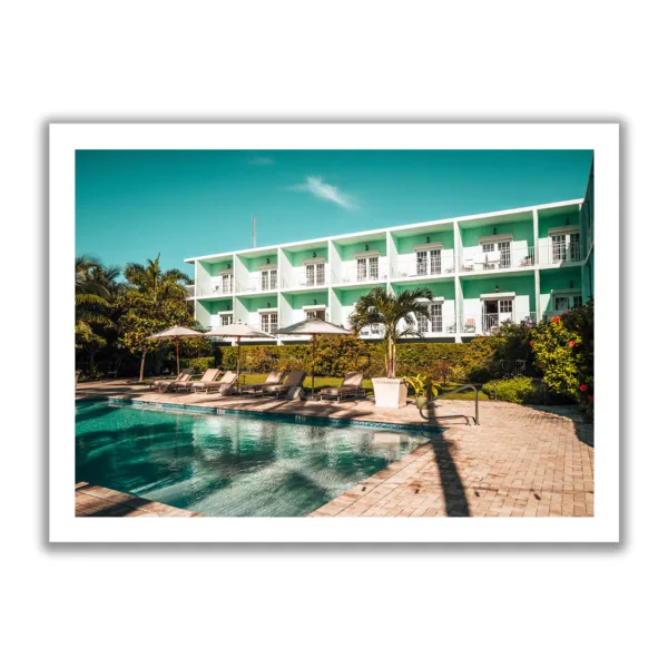 Picture of the pool area of the Grassy Flat Hotel. Blue sky, pool and loungers. Morning view.