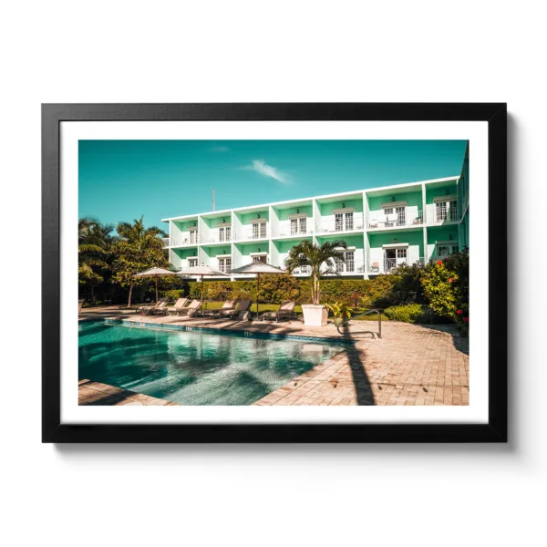 Picture of the pool area of the Grassy Flat Hotel. Blue sky, pool and loungers. Morning view.