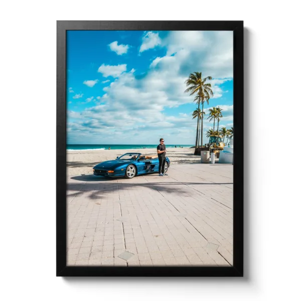 Young man stands in front of a blue Ferrari on the beach in Fort Lauderdale.