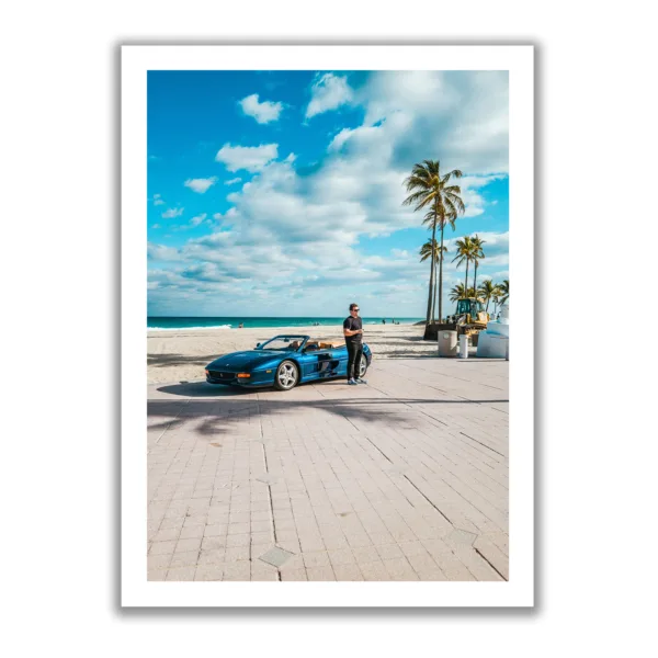 Young man stands in front of a blue Ferrari on the beach in Fort Lauderdale.