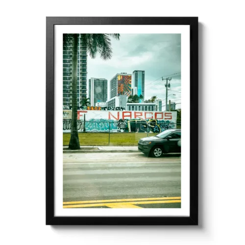 Bildaufnahme das einen Graffiti Narcos Schriftzug in Rot auf einer Mauer von Miami zeigt.