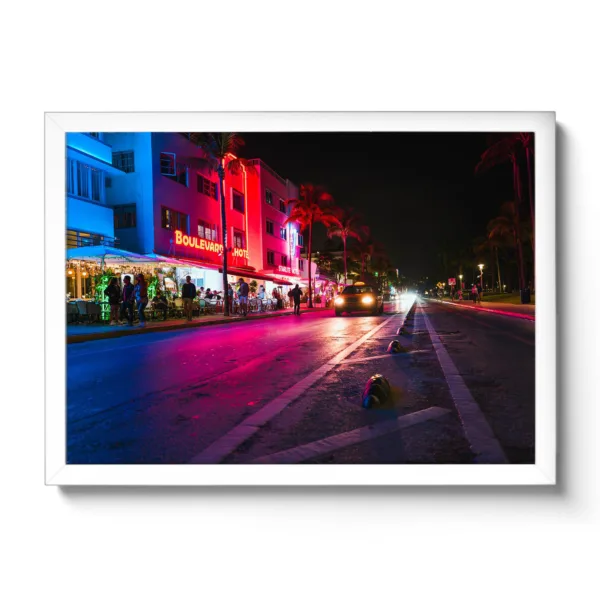 Image of Ocean Drive in Miami at night. Neon lights and a moving car.