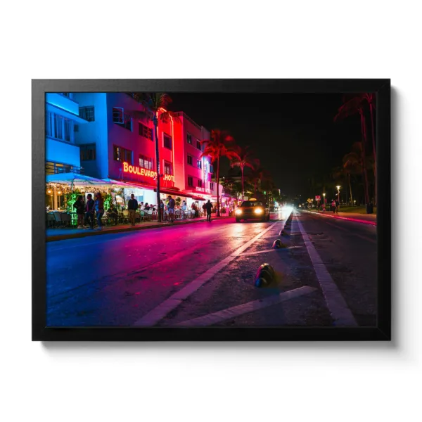 Image of Ocean Drive in Miami at night. Neon lights and a moving car.