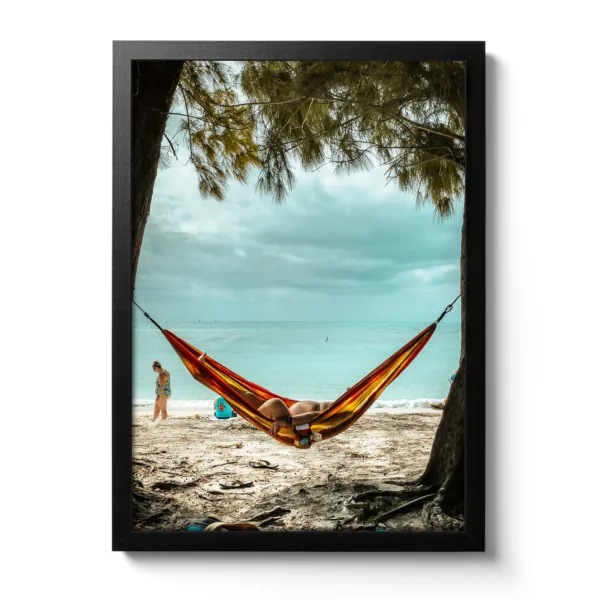 Bildaufnahme eines Mannes, der am Strand unter Palmen in einer Hängematte liegt und das Meer im Hintergrund ist. Das lustige dabei, man sieht sein kleines Bäuchlein.