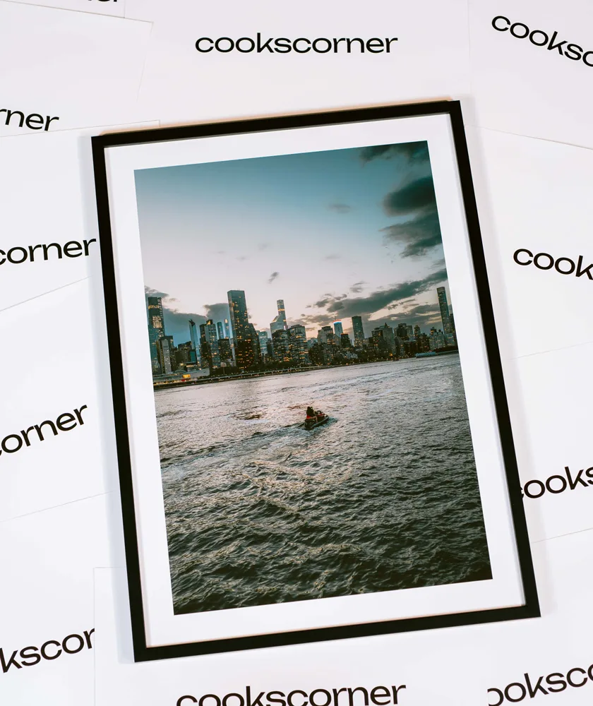 Gerahmtes Foto einer Person auf einem Jetski vor der Skyline von New York, umgeben von „cookscorner“-Logos.
